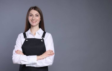 Gri arka planda gülümseyen baristanın portresi. Metin için boşluk