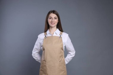 Gri arka planda gülümseyen baristanın portresi