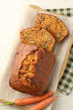 Ev yapımı havuçlu kek, fındıklı ve sebzeli beyaz desenli masa, üst manzara.