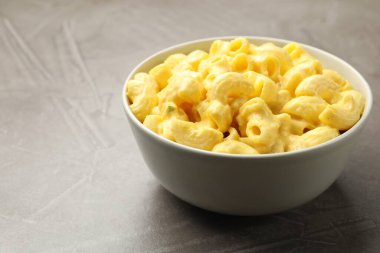 Gri masada peynir soslu leziz makarna, yakın plan. Metin için boşluk