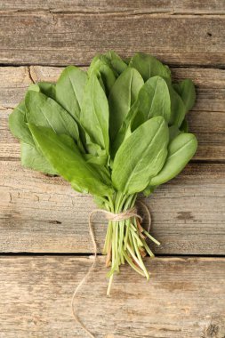 Tahta masanın üstünde taze yeşil kuş yaprakları var.