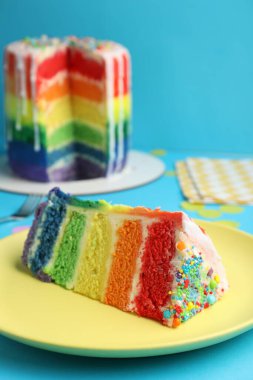 Açık mavi masadaki lezzetli gökkuşağı pastası, yakın plan.