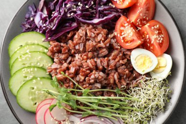 Gri masada kahverengi pirinçli lezzetli bir salata.