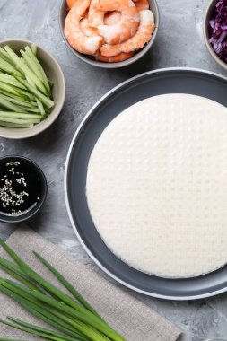 Pirinç kağıt çarşaflar ve açık gri masa üzerindeki farklı malzemeler, düz uzanmış.