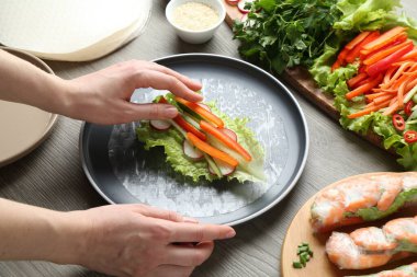 Gri ahşap masada nefis börek yapan kadın, yakın plan.