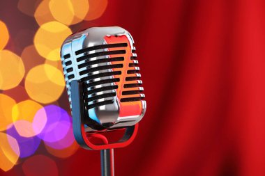 Kırmızı perdeye karşı bir klasik mikrofon, mesaj için yer. Bokeh etkisi