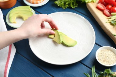 Mavi ahşap masada nefis börek yapan bir kadın, yakın plan.