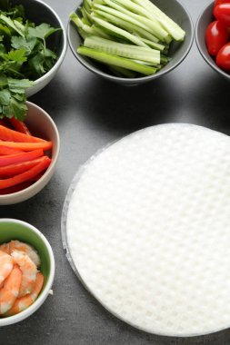 Pilav kağıtları ve farklı malzemeler koyu gri masada, üst tarafta.