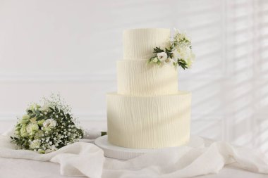 Çiçekli düğün pastası ve kapalı masa desenli lezzetli bir pasta.