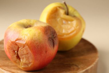 Bej arka planda iki çürük elma, yakın plan.