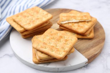 Beyaz mermer masada lezzetli tuzlu krakerler, yakın plan.