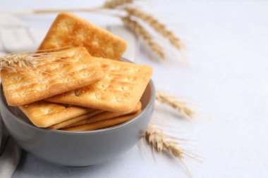 Beyaz masadaki buğday dikenli tuzlu krakerler, yakın plan. Metin için boşluk