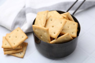 Beyaz fayanslı masada lezzetli tuzlu krakerler, yakın plan.