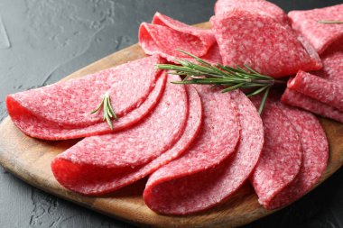 Siyah masada servis edilen biberiyeli lezzetli sosis dilimleri, yakın plan.