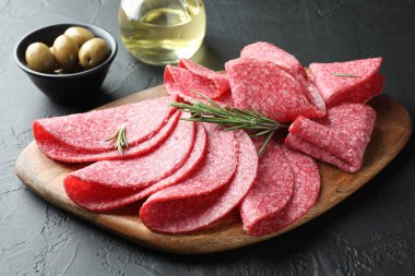 Siyah masada servis edilen biberiyeli lezzetli sosis dilimleri, yakın plan.