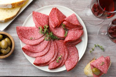 Dilimler dolusu lezzetli sosis ve kekik hafif ahşap masada servis edilir.