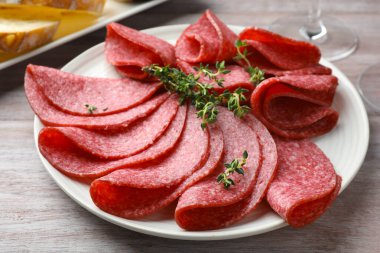 Hafif ahşap masada servis edilen kekik dilimli lezzetli sosisler.