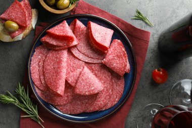 Gri masada servis edilen leziz sosis dilimleri.