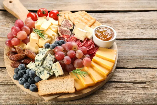Tahta masadaki farklı lezzetli peynir çeşitleri ve diğer atıştırmalıklar, yakın plan. Metin için boşluk