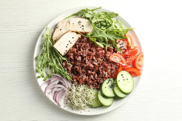 Beyaz ahşap masada kahverengi pirinçli nefis bir salata.