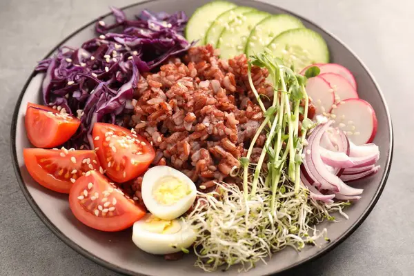 Gri masada kahverengi pirinçli lezzetli salata, yakın plan.