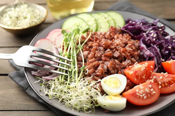 Tahta masada servis edilen kahverengi pirinçli lezzetli salata, yakın plan.