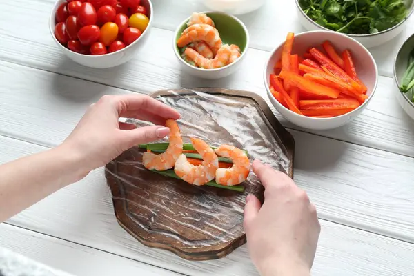 Beyaz ahşap masada nefis börek yapan bir kadın.