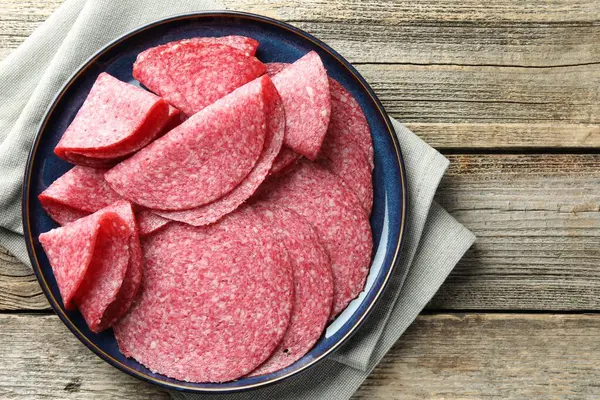 Ahşap masada leziz sosis dilimleri, üst manzara.