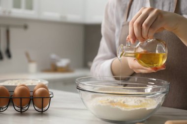 Khinkali yapıyorum. Kadın mutfaktaki masada kaseye yağ koyuyor, yakın plan.