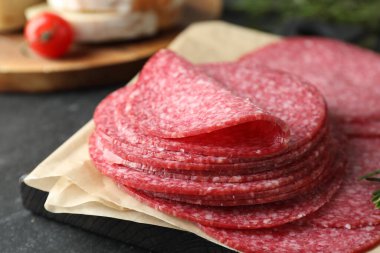 Lezzetli füme sosis dilimleri siyah masada, yakın plan.