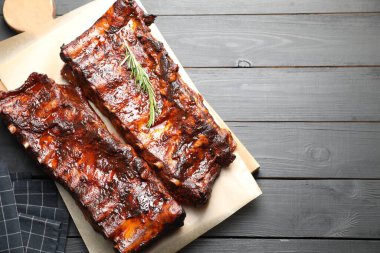 Siyah ahşap masa üzerinde biberiyeli domuz pirzolası. Metin için boşluk