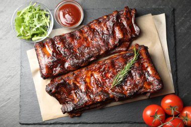 Biberiye, domates, sos ve salata ile servis edilen kızarmış domuz pirzolası.