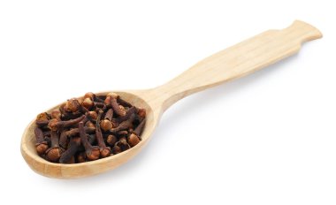 Aromatik karanfiller beyaz kaşıkta izole edilmiş.