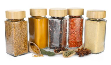 Beyaz kavanozlardaki farklı aromatik baharatlar.