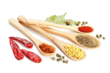 Beyaz kaşıklardaki farklı aromatik baharatlar.