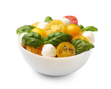 Sarı domatesli taze salata, fesleğen ve mozzarella peyniri beyaz kasede izole edilmiş.