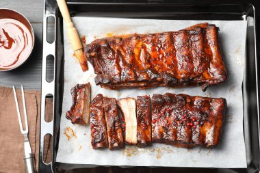 Lezzetli kaburgalar, sos ve fırça gri ahşap masa, düz uzanmış