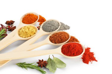 Beyaz kaşıklardaki farklı aromatik baharatlar.