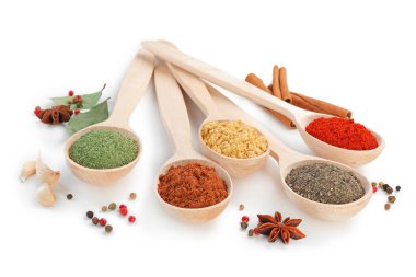 Beyaz kaşıklardaki farklı aromatik baharatlar.