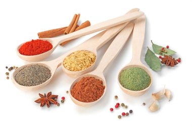 Beyaz kaşıklardaki farklı aromatik baharatlar.