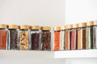 Farklı aromatik baharatlar kavanozlarda, beyaz raflarda, kapalı mekanlarda.