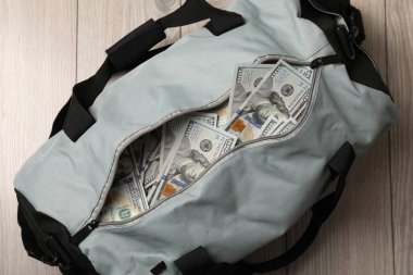 Tahta arka planda bir çanta dolusu banknot.