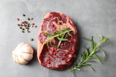 Gri desenli masada çiğ et ve baharat var.