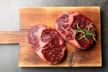 Gri masa üzerinde çiğ et ve baharat parçaları.