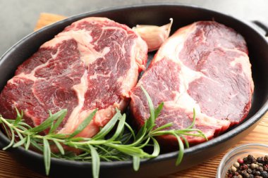 Yemek masasında çiğ et ve baharat parçaları, yakın plan.