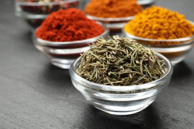 Gri masada farklı aromatik baharatlar, yakın plan.