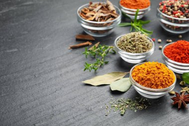 Gri masada farklı aromatik baharatlar, yakın plan. Metin için boşluk