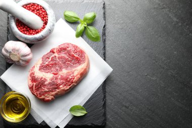 Bir parça çiğ et ve baharat siyah masada, düz yerde. Metin için boşluk