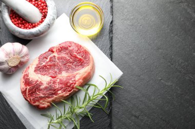 Bir parça çiğ et ve baharat siyah masada, düz yerde. Metin için boşluk