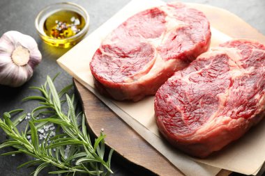 Çiğ et parçaları ve baharatlar siyah masada, yakın plan.